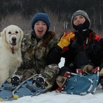 Three guests with their two dogs in winter snow
