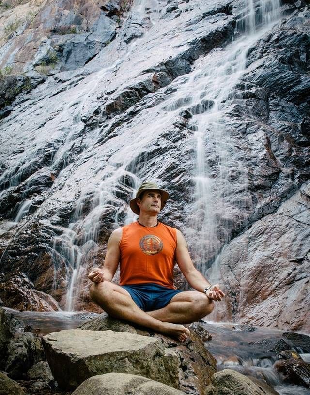 Blaine Carter mediating in front of a waterfall