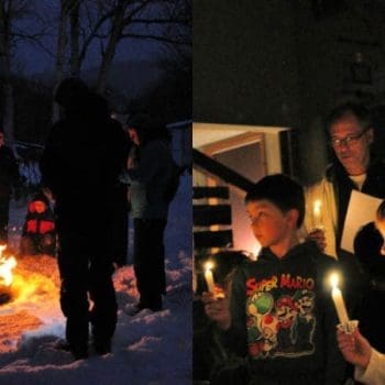 Children standing around a campfire and holding candles.