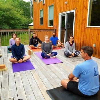 Group doing yoga on an outdoor deck