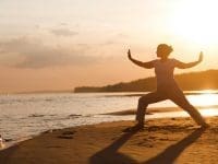 A woman practices Qi Gong during a wellness retreat amid the shore of Cape Breton Island.
