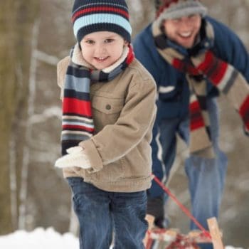 A young boy playfully runs away from his father during a winter getaway in Nova Scotia.