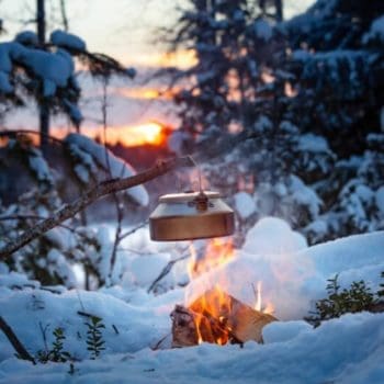 A small kettle hangs over a camp fire during an early winter morning on Cape Breton Island, Nova Scotia.