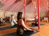 people doing yoga inside a yurt