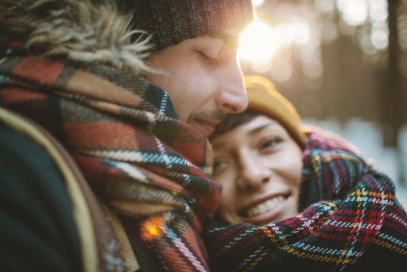 Romantic Getaways Cape Breton: A young couple share a warm embrace amid the crisp winter air of Cape Breton Island.