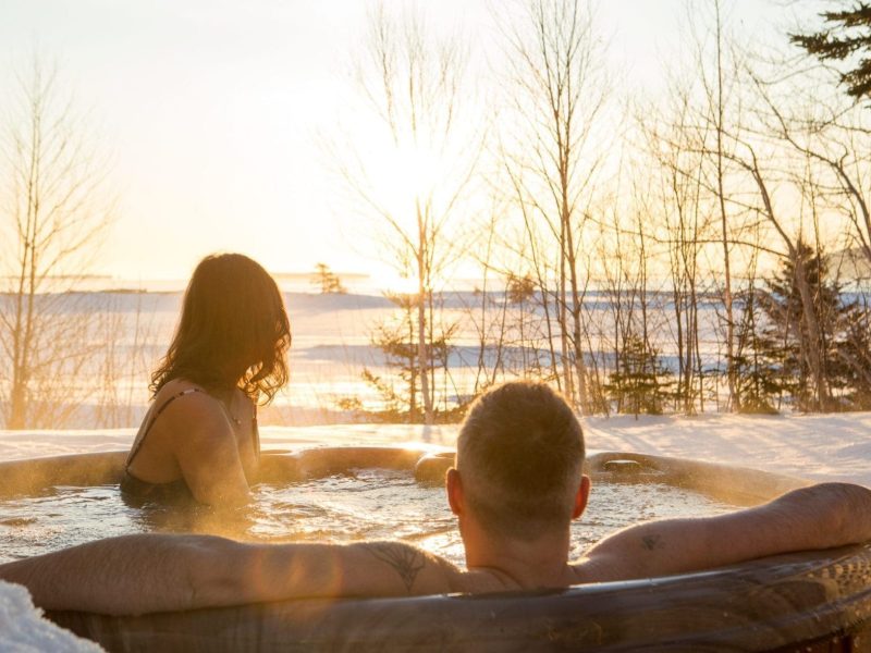 Stay-Chalets Couple in an outdoor hot tub in winter.
