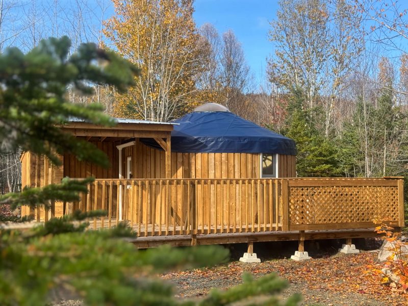 The Highlands Yurt at Cabot Shores Highland Yurt exterior surrounded by trees at Cabot Shores Wilderness Resort